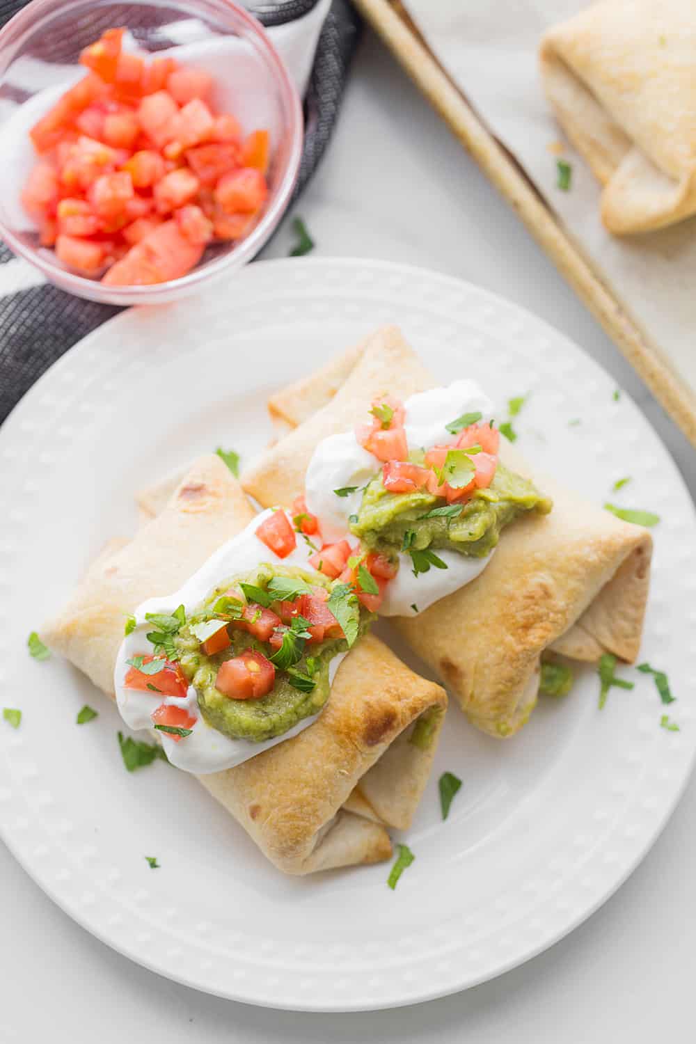 Baked Chicken Chimichangas - Baked chicken chimichangas make for a fun, flavorful alternative to tacos for Taco Tuesday. They're also a super tasty freezer meal! #mexicanrecipe #mexicanfood #chimichangas #easyrecipe #freezermeal #freezerrecipe #halfscratched #tacotuesday