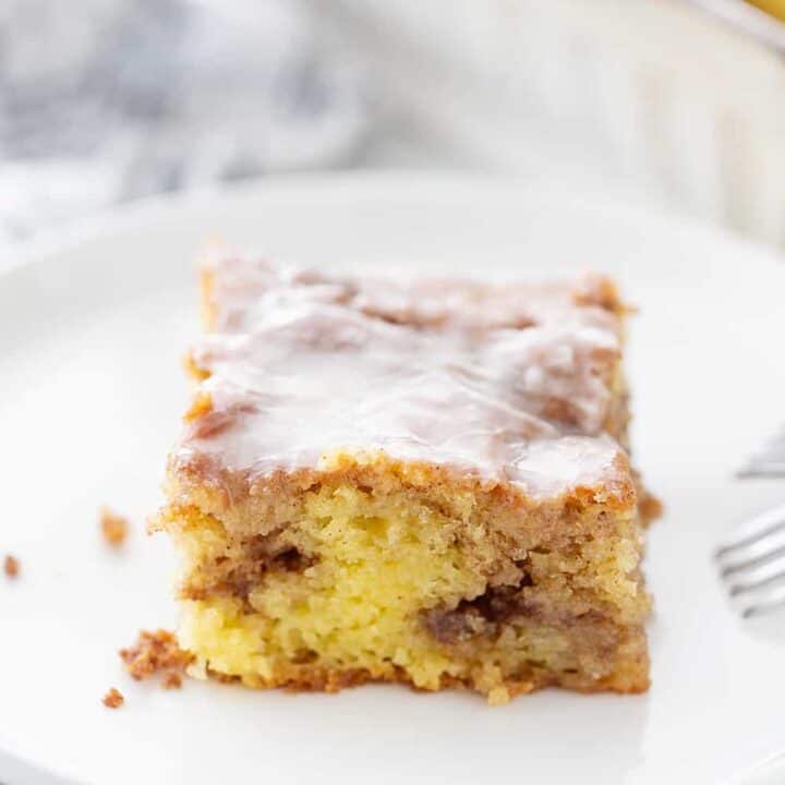 Honey Bun Cake - There's nothing like hot, cinnamon-swirled yellow cake topped with powdered sugar icing. Dessert or breakfast? Honey bun cake is both! #honeybun #cinnamonroll #cakemix #cakemixrecipe #honeybuncake #baking #dessert #brunch #halfscratched #yellowcake #easyrecipe