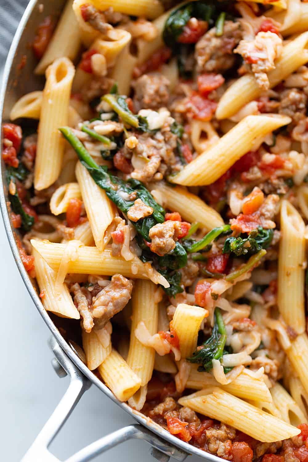 Tomato and Spinach Pasta Toss - With this easy tomato and spinach pasta toss recipe in your rotation, you can have a delicious, hearty meal ready in minutes! #pasta #italianfood #halfscratched #tomato #spinach #pastarecpie #maindish