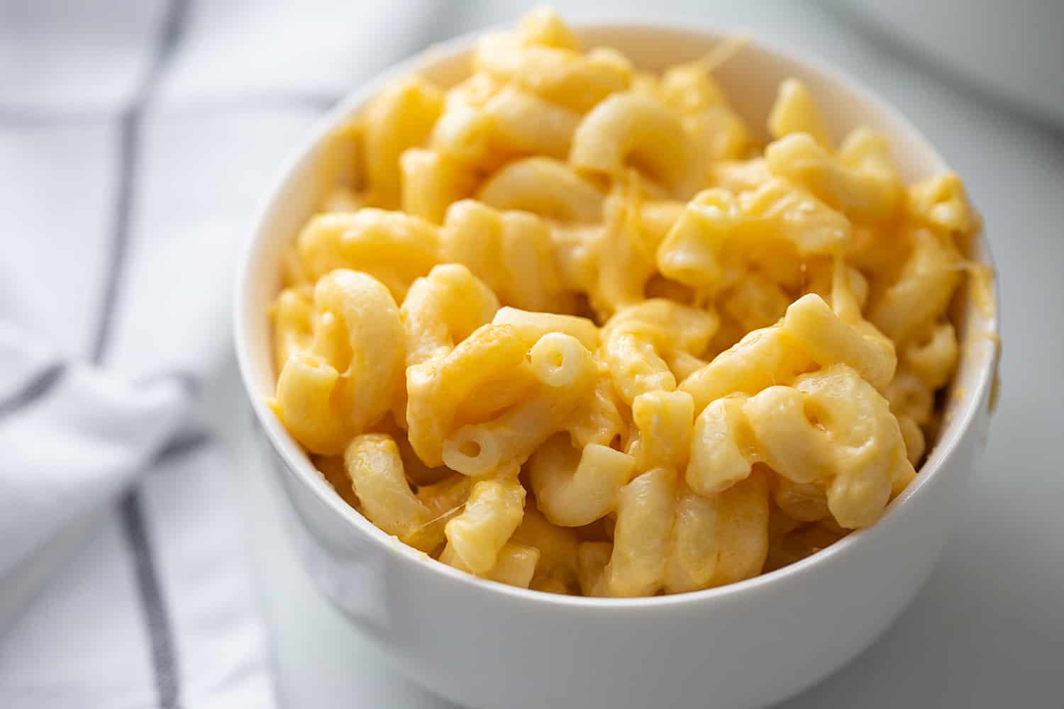 Easy Slow Cooker Mac and Cheese - Even the pickiest eaters will love easy slow cooker mac and cheese: a combo of sharp cheddar and Colby Jack plus a few surprise ingredients. #macandcheese #easyrecipe #halfscratched #slowcooker #pasta