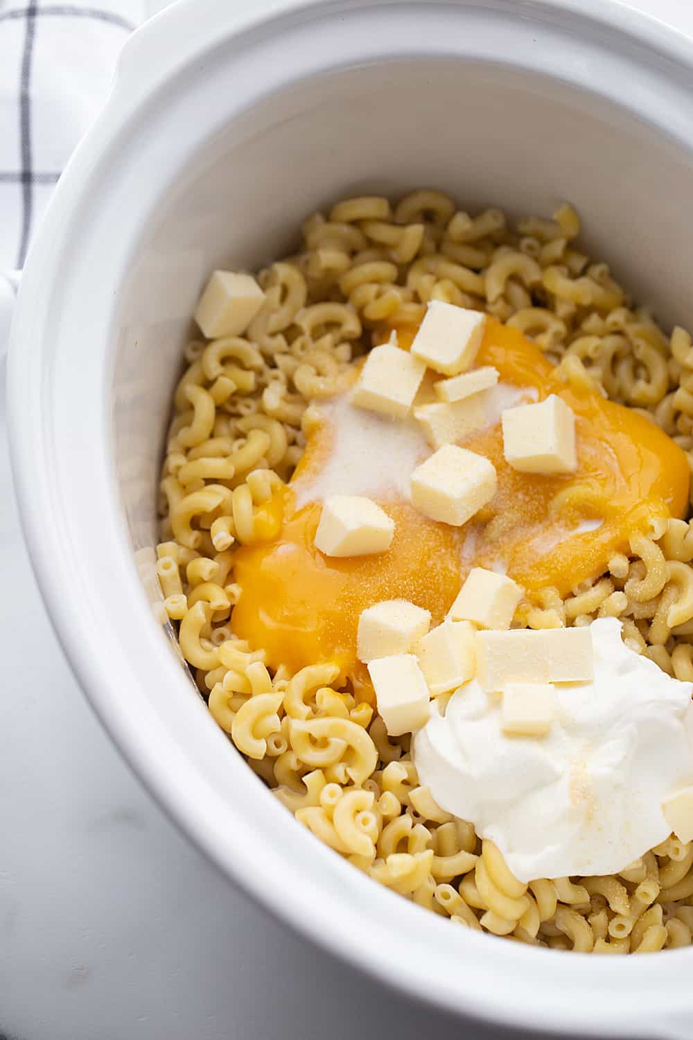Easy Slow Cooker Mac and Cheese - Even the pickiest eaters will love easy slow cooker mac and cheese: a combo of sharp cheddar and Colby Jack plus a few surprise ingredients. #macandcheese #easyrecipe #halfscratched #slowcooker #pasta