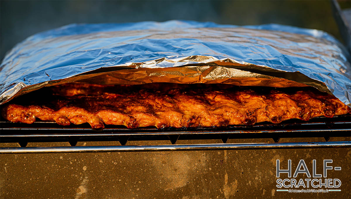 Ribs covered in foil in smoker