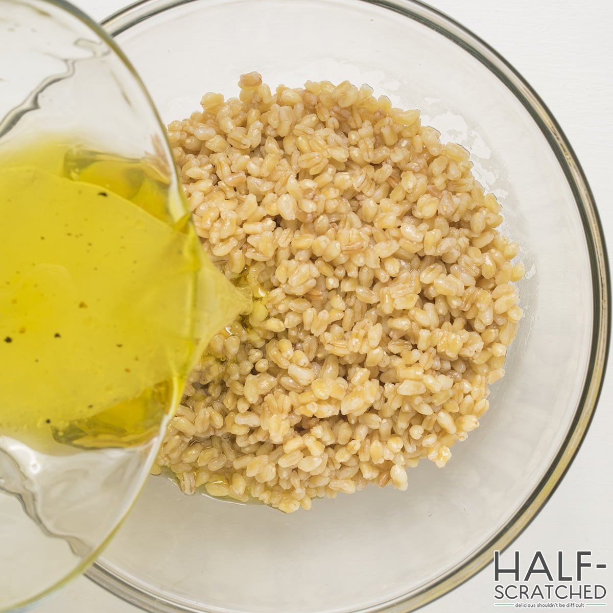 Adding the vinaigrette to the warm farro