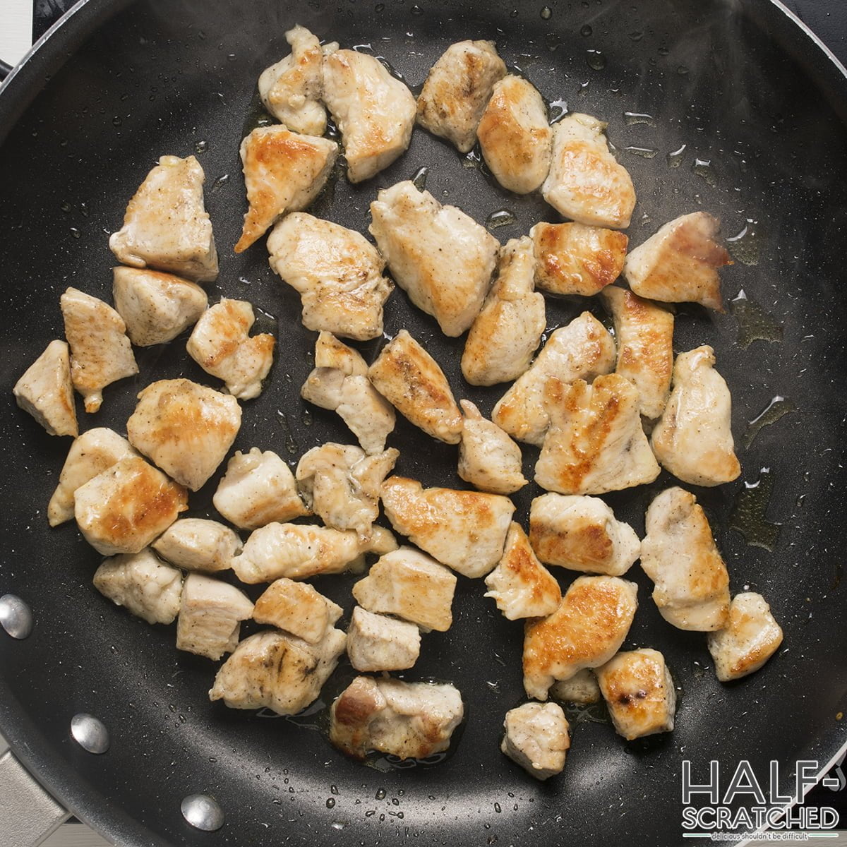 A frying pan with chicken pieces