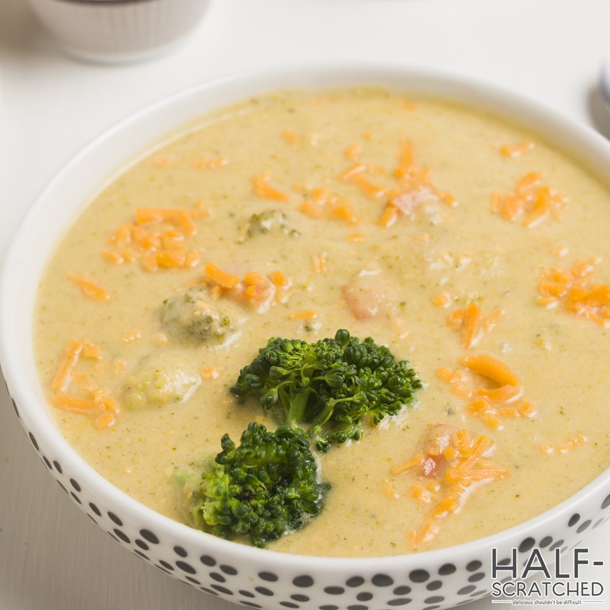 Close view of a bowl with broccoli and cheddar soup
