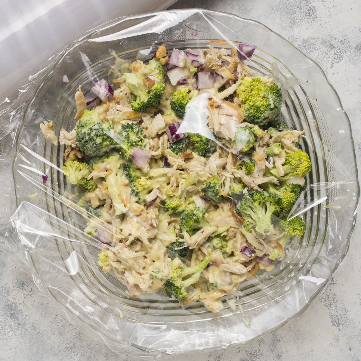A covered bowl with Chicken Salad Chick's Broccoli Salad