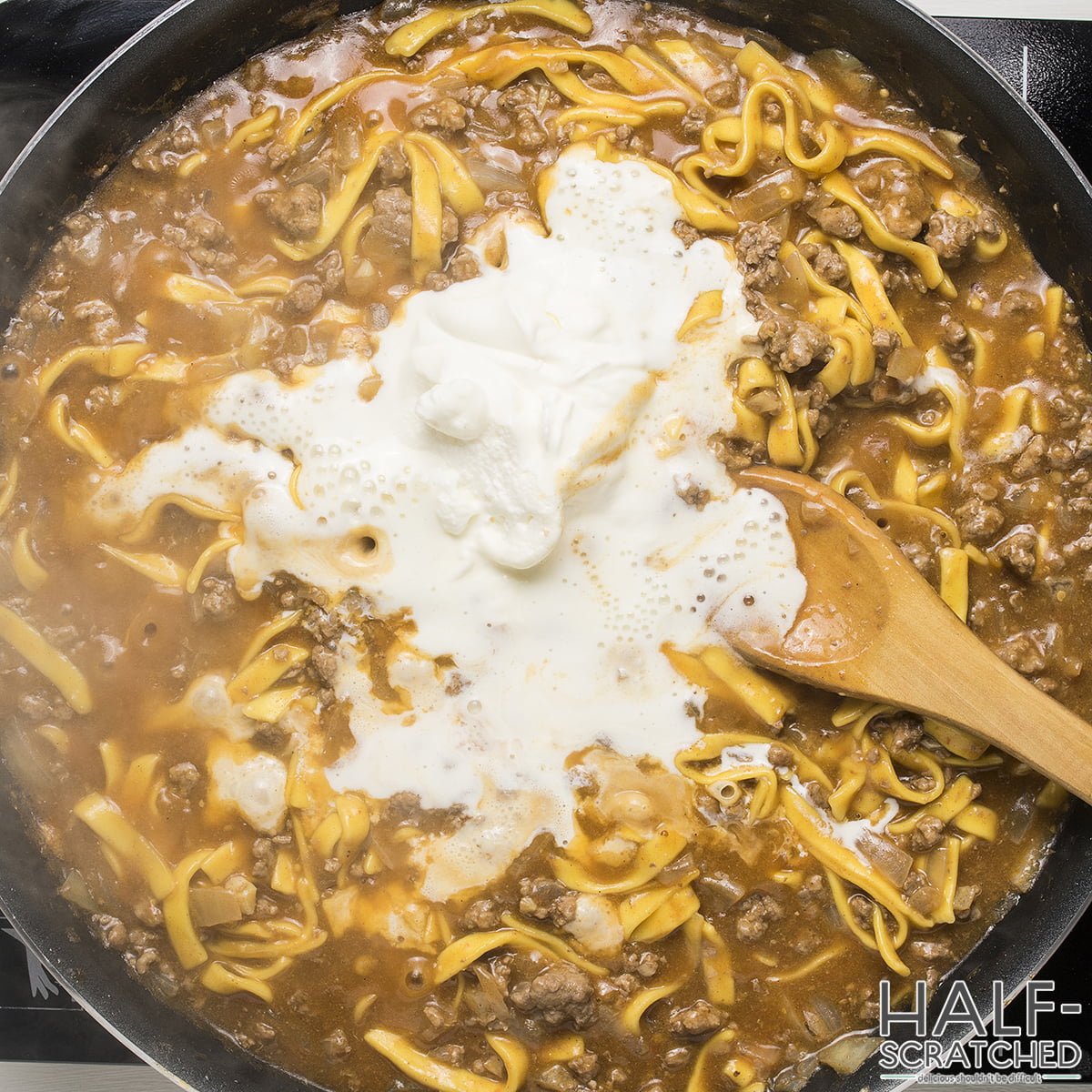 Adding the sour cream and heavy ncream to a beef Noodle skillet recipe