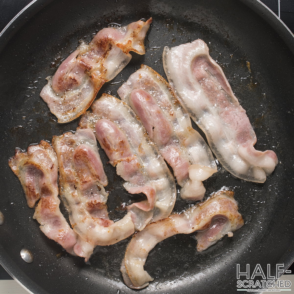 Fried bacon rashers in a frying pan