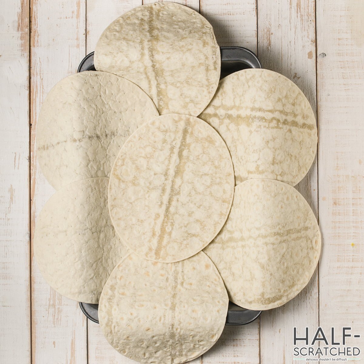 Several tortillas on a baking sheet