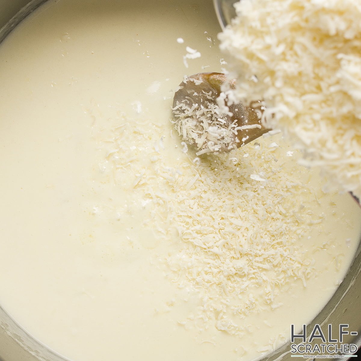 Adding Parmesan cheese to the sauce in the Crispy Chicken Fritta recipe