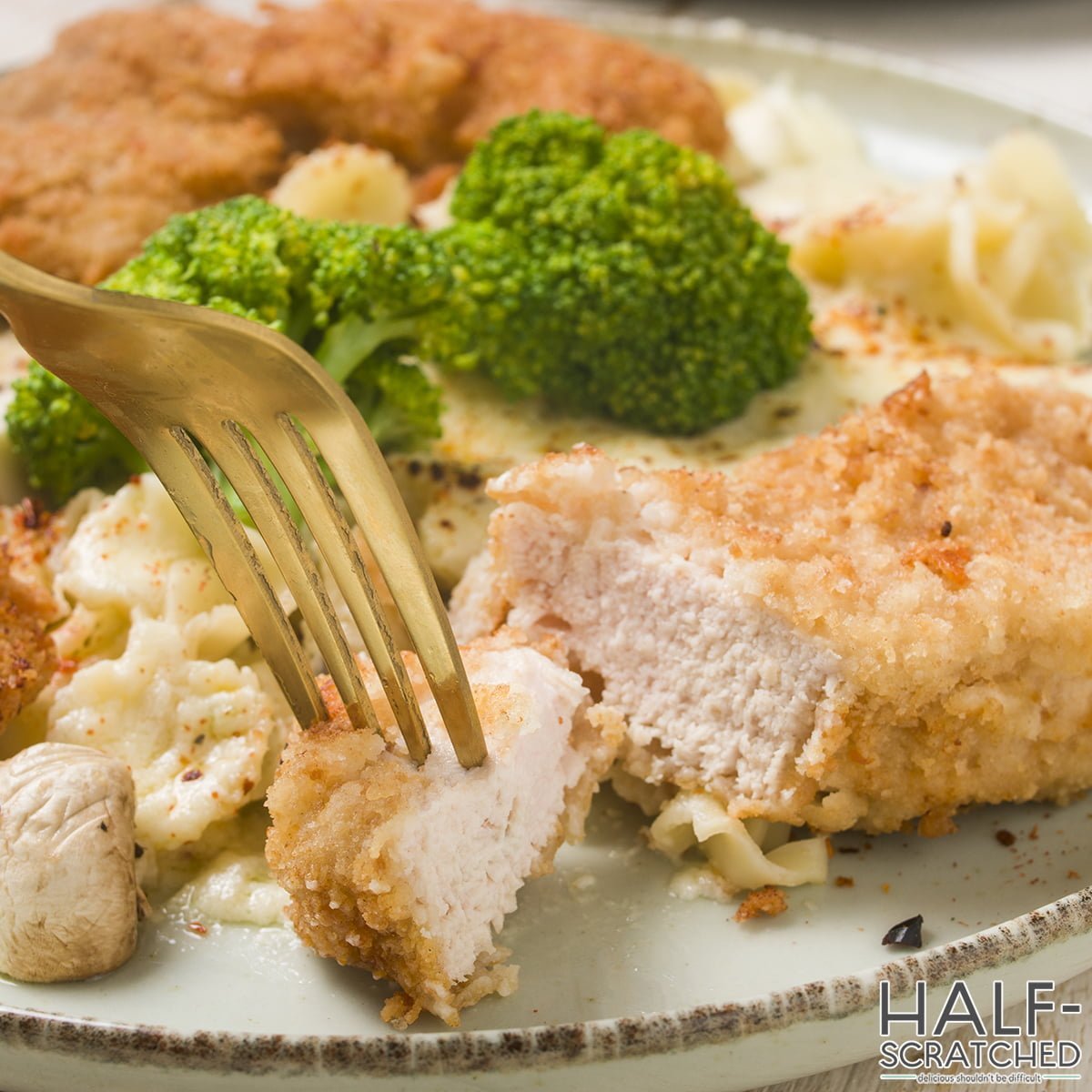 A fork with a piece of Crispy Chicken Fritta