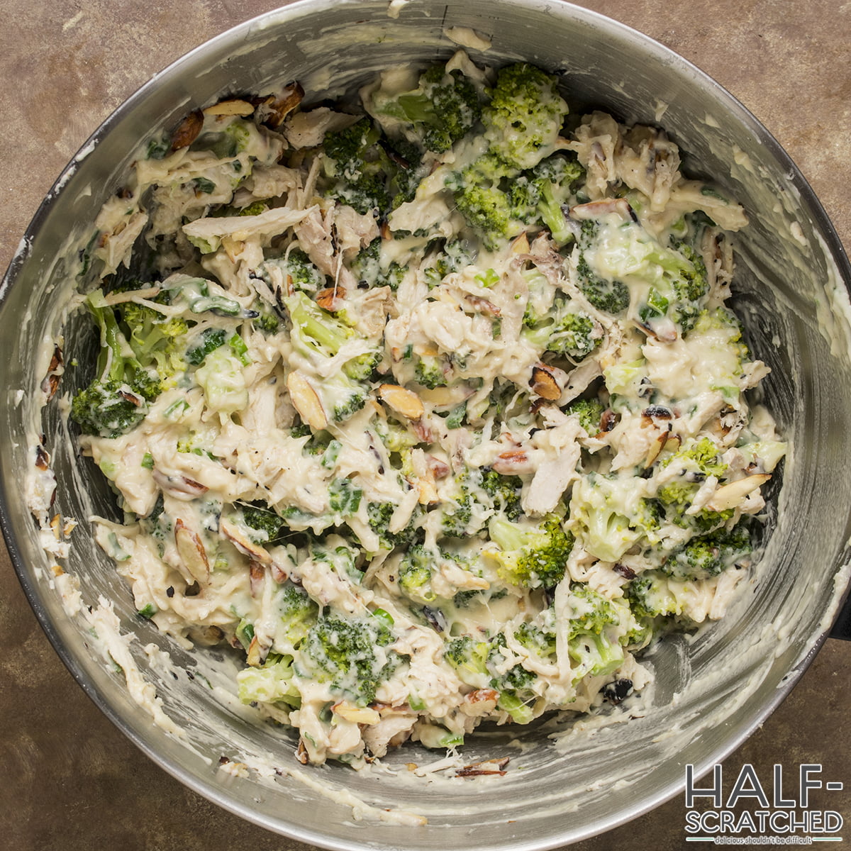 Sauce with broccoli, chicken, and almonds in a large bowl