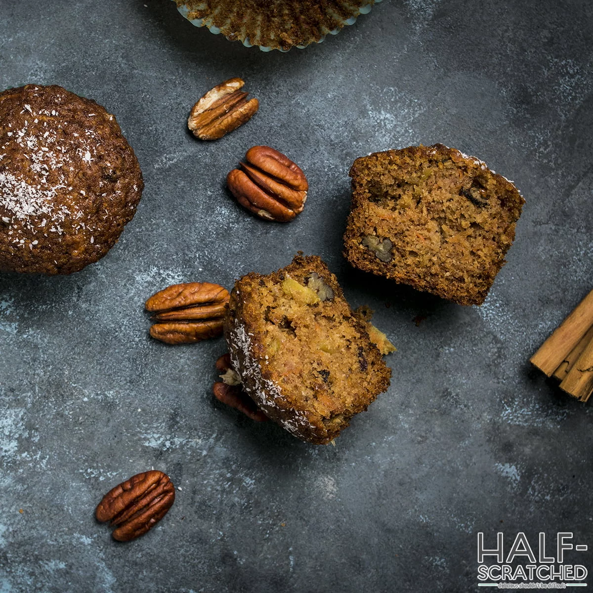 Morning glory muffin cut in half with pecans and cinnamon sticks